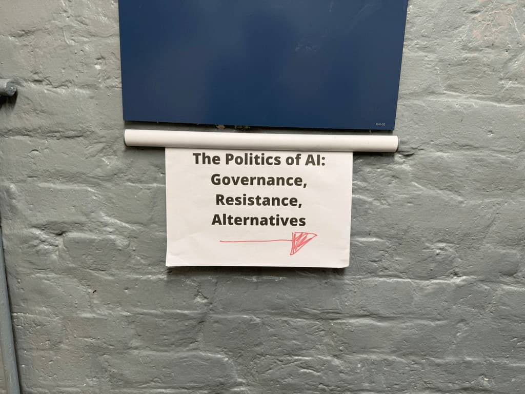 Poster on a door that reads The Politics of AI: governance, resistance, alternatives